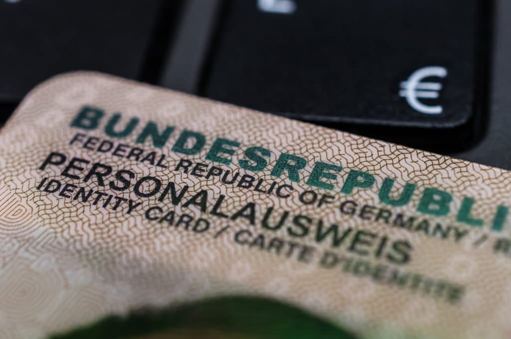Nahaufnahme eines deutschen Personalausweises mit sichtbarer Aufschrift „Bundesrepublik Deutschland“ und Euro-Symbol im Hintergrund