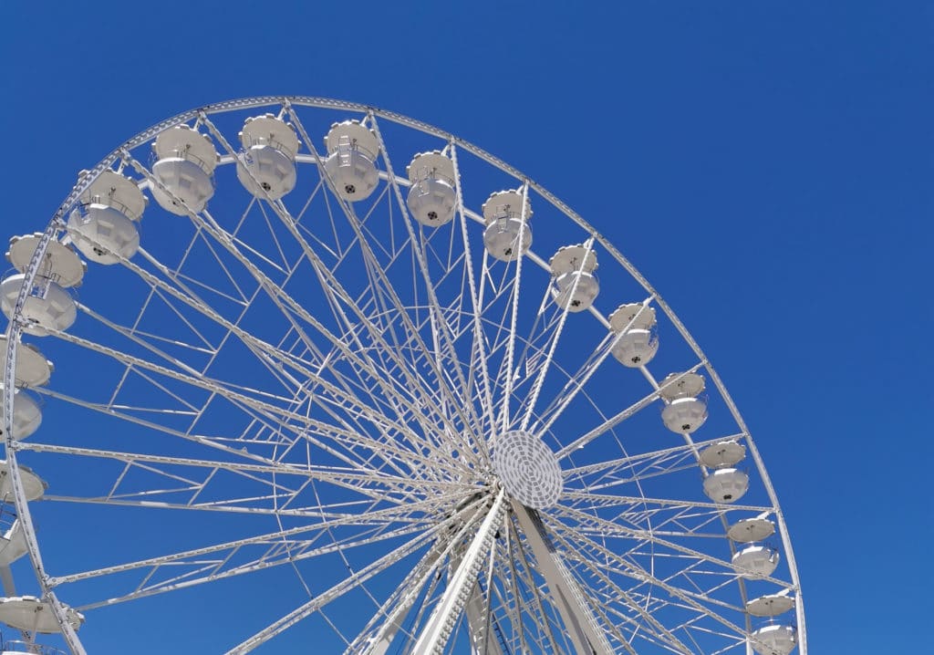 Riesenrad in Deggendorf Nahaufnahme eines weißen Riesenrads mit geschlossenen Gondeln vor blauem Himmel