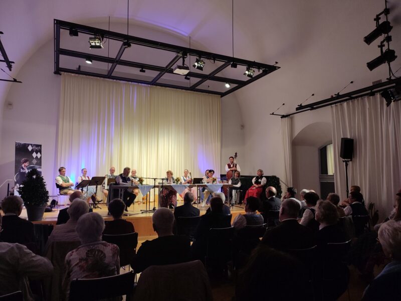 Konzert des Vereins M23 in Deggendorf Musikerinnen und Musiker spielen vor Publikum in einem festlich beleuchteten Saal.