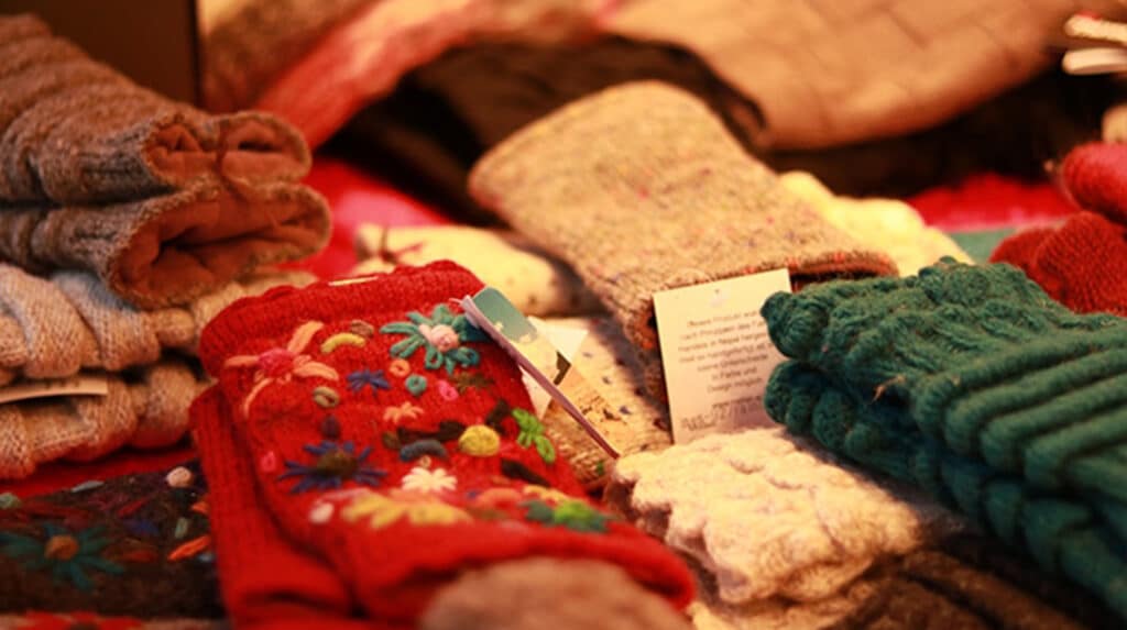 Handgefertigte Wollwaren auf dem Adventsmarkt in Deggendorf Bunte handgefertigte Wollwaren, darunter bestickte und gestrickte Handschuhe, auf einem Adventsmarktstand
