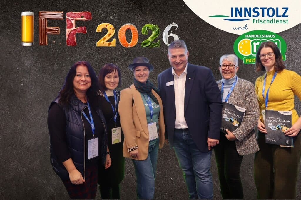 Sechs Personen posieren vor einer Fotowand mit der Aufschrift „IFF 2026“ sowie Logos von Innstolz Frischdienst und Handelshaus Hartl.