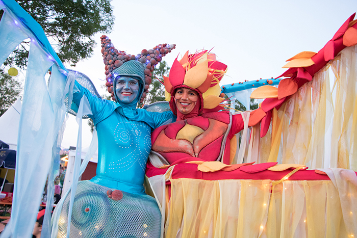 Donaufest 2019: Kostümierte Teilnehmerinnen auf einem Festwagen Zwei kostümierte Frauen stehen lächelnd auf einem bunt geschmückten Festwagen mit Vorhängen und Dekorationen.