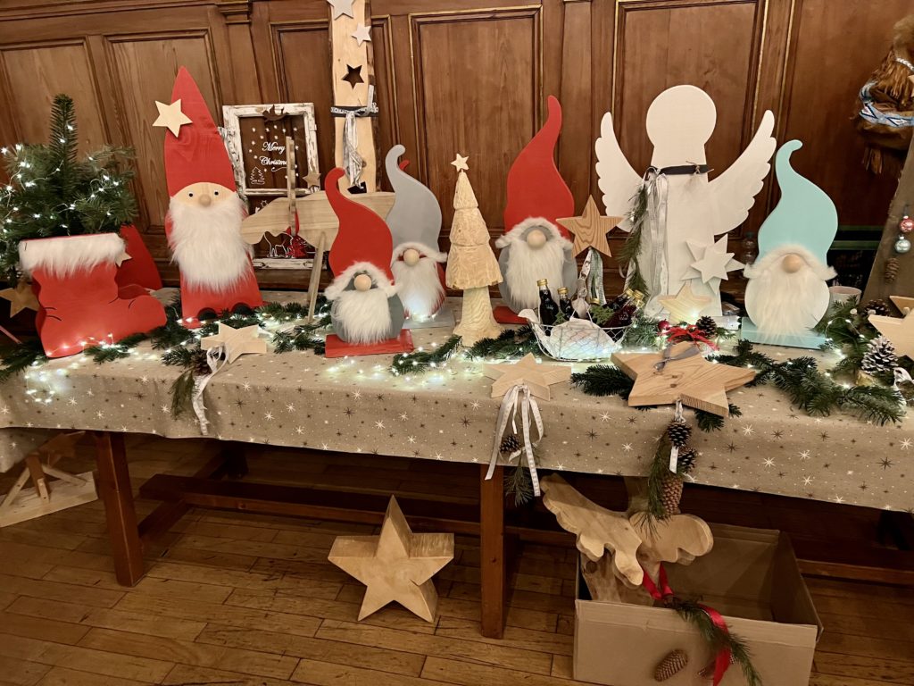 Kunsthandwerkermarkt im Advent in Deggendorf Dekorierter Stand mit handgefertigten Weihnachtsfiguren, Engeln, Wichteln und Sternen auf einem Advents-Kunsthandwerkermarkt