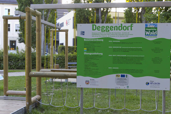 Bewegungsparcours in Deggendorf Hinweistafel zum Bewegungsparcours in Deggendorf neben Kletter- und Balanciergeräten im Außenbereich
