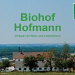 Ländliche Hofanlage vor einer weiten Landschaft; darüber steht „Biohof Hofmann – Verkauf von Rind- und Lammfleisch“, rechts ist das Bioland-Siegel zu sehen.