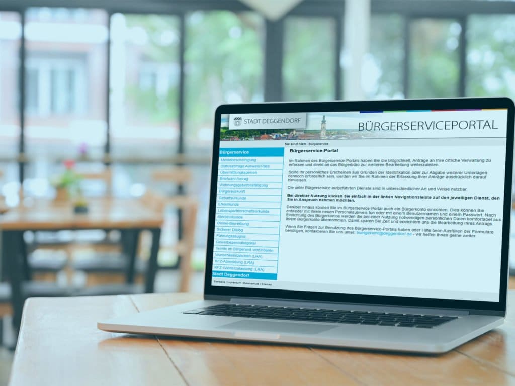 Laptop mit der geöffneten Webseite des Bürgerserviceportals der Stadt Deggendorf auf einem Holztisch