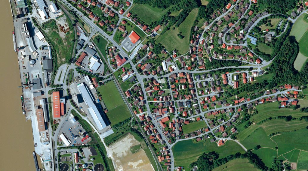 Luftaufnahme von Deggenau mit Donau, Hafen- und Industrieanlagen, Wohngebieten, Straßen und umliegenden Feldern