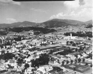 Historische Luftaufnahme von Schaching in Deggendorf Schwarzweiße Luftaufnahme von Schaching mit Wohnhäusern, Straßen, Feldern und der hügeligen Landschaft bei Deggendorf
