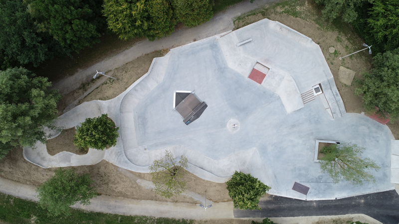 Luftaufnahme eines weitläufigen Skateparks mit Rampen, Schalen und begrünten Wegen