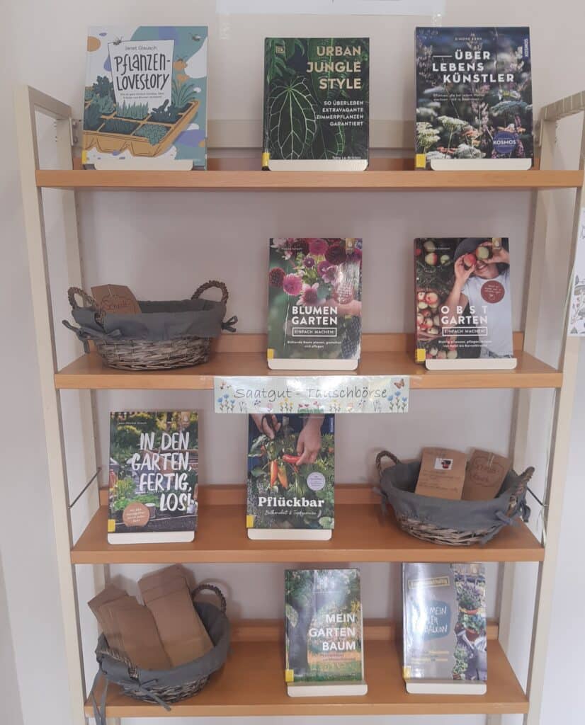 Gartenbücher und Pflanzensamen in einer Büchereiauslage Holzregal mit Gartenbüchern, Pflanzensamen und geflochtenen Körben in einer Innenraumauslage