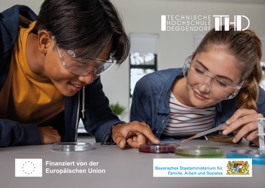 Zwei Jugendliche mit Schutzbrillen untersuchen gemeinsam eine Petrischale und arbeiten mit einer Pipette an einem Labortisch.