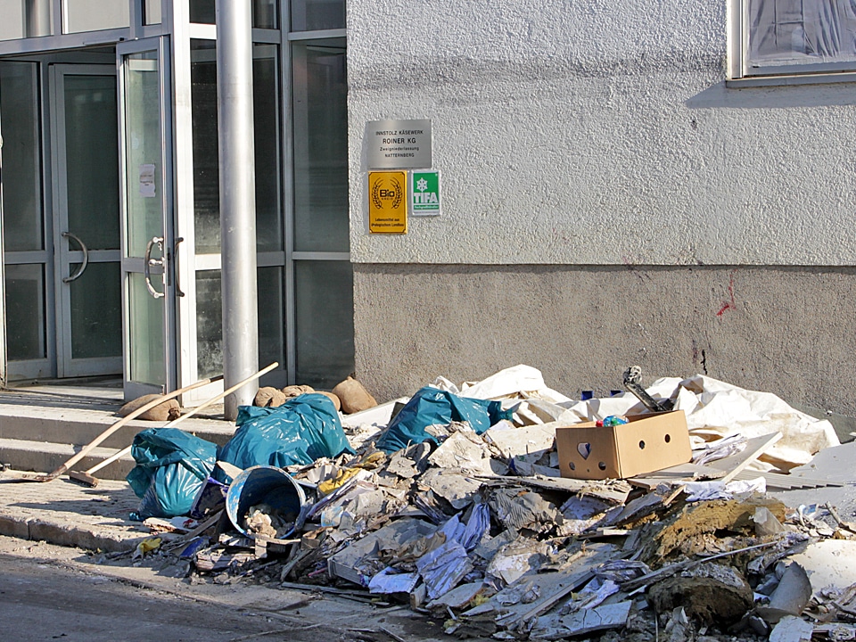 Sperrmüll mit Plastiksäcken, Kartons, Holz und Bauschutt liegt vor dem Eingang eines Gebäudes.