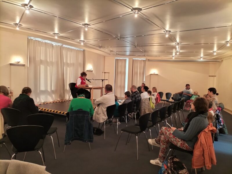 M23 14 – Veranstaltung des Vereins in Deggendorf, Saison 2023 Veranstaltung in einem Saal mit sitzendem Publikum und einer musizierenden Person auf einer kleinen Bühne