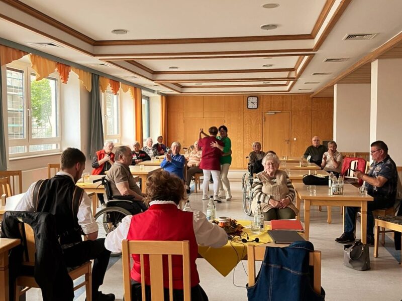 M23 17 – Veranstaltung des Vereins in Deggendorf, Saison 2023 Menschen sitzen bei einer geselligen Veranstaltung an Tischen in einem hellen Saal.