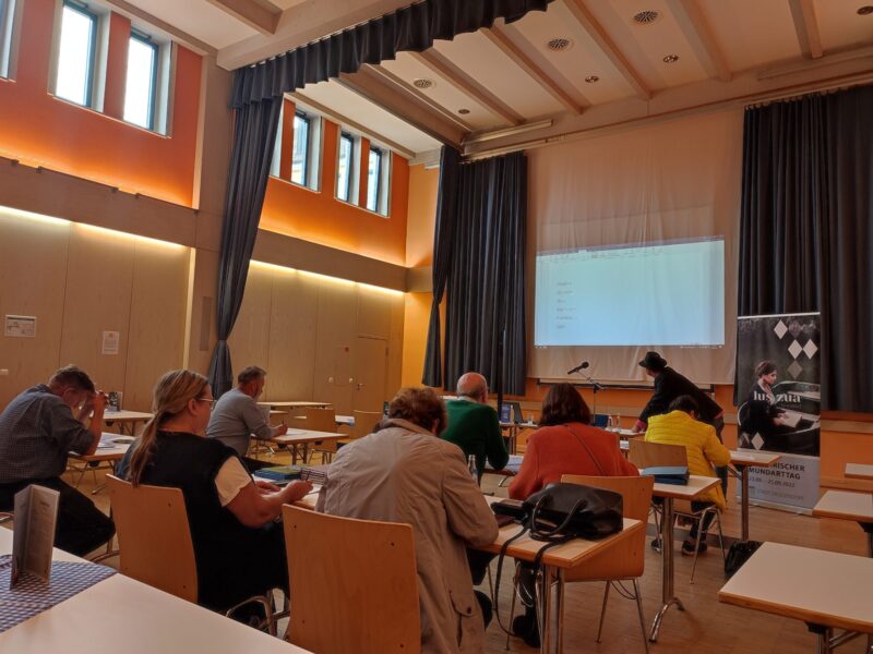 Vereinsveranstaltung in Deggendorf 2023 Teilnehmende sitzen bei einer Vereinsveranstaltung in einem Saal und verfolgen eine Präsentation auf einer Leinwand.
