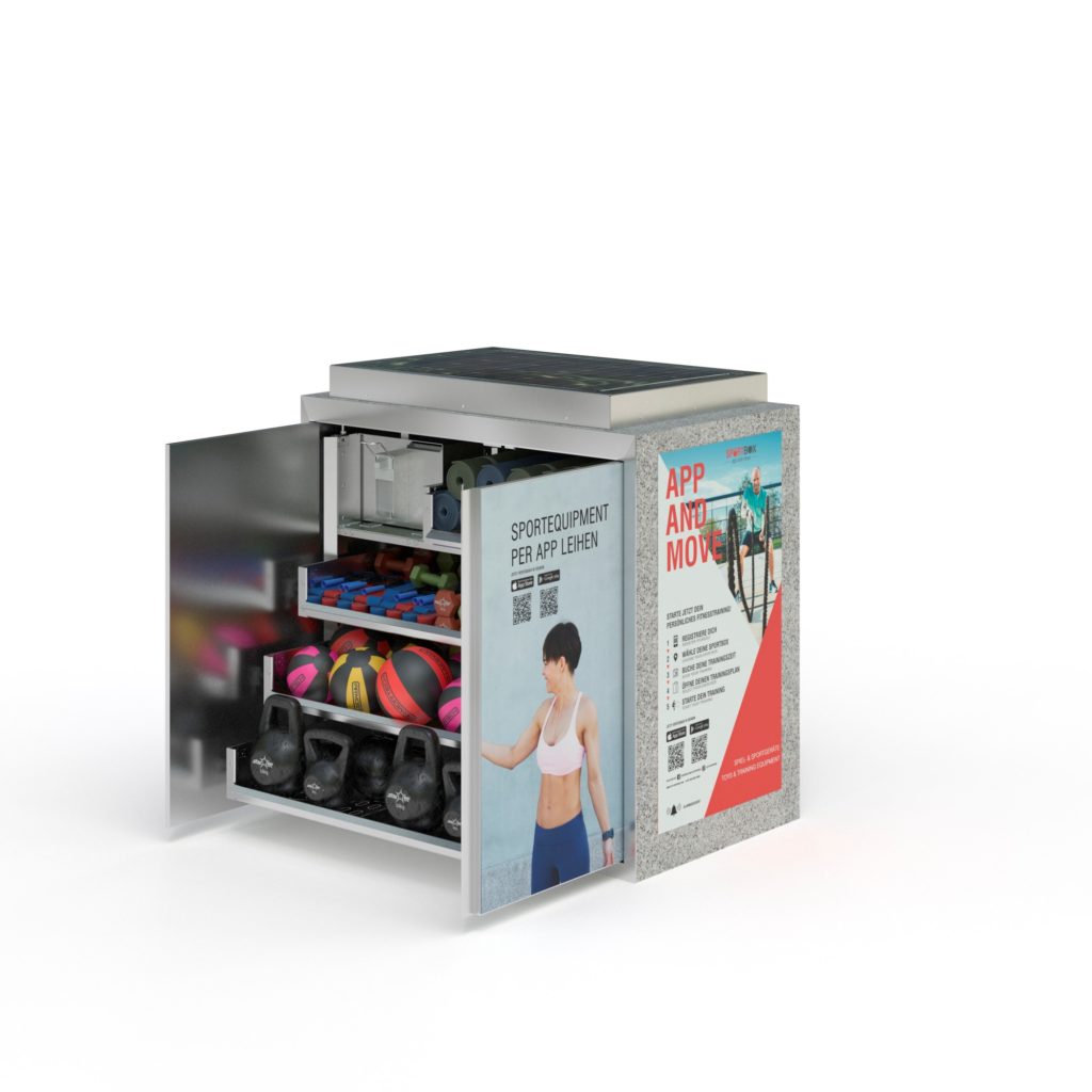 Geöffnete Sportbox mit Bällen, Kettlebells und weiterem Trainingszubehör; an der Außenseite hängen Plakate für ein Bewegungsangebot.