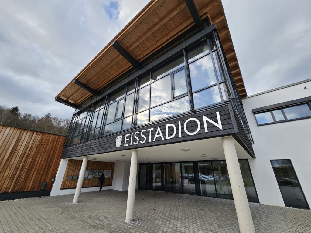 Eisstadion in Deggendorf Frontansicht des Eisstadions mit verglastem Eingangsbereich, überdachtem Vorplatz und dem Schriftzug „EISSTADION“.