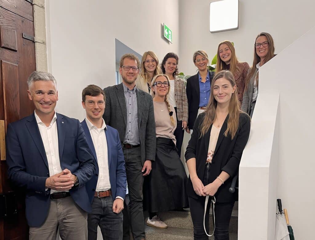 Gruppenfoto mit neun Personen bei einem Innenstadtaustausch in einem Gebäude