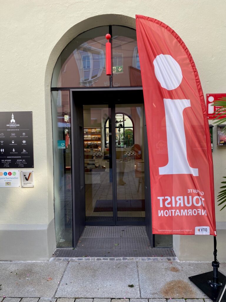 Eingang der Tourist-Information mit roter Fahne vor der Tür