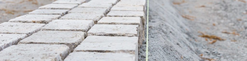 Nahaufnahme einer Reihe heller Pflastersteine neben einem befestigten Randbereich