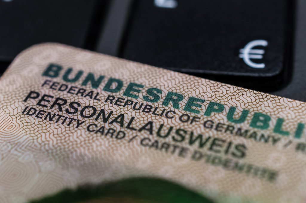 Nahaufnahme eines deutschen Personalausweises neben einer Euro-Münze